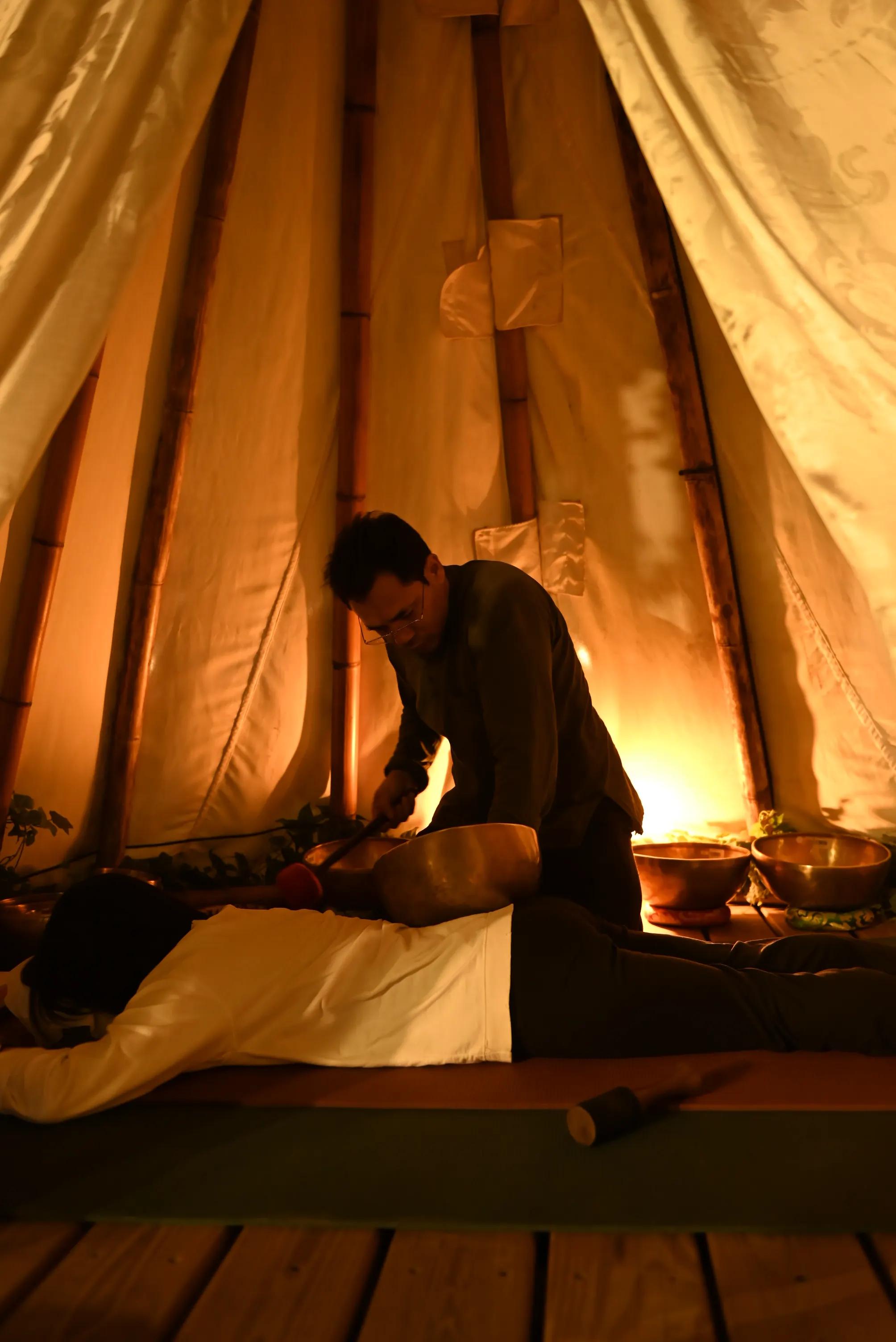 A private sound healing session with a singing bowl on a client's back