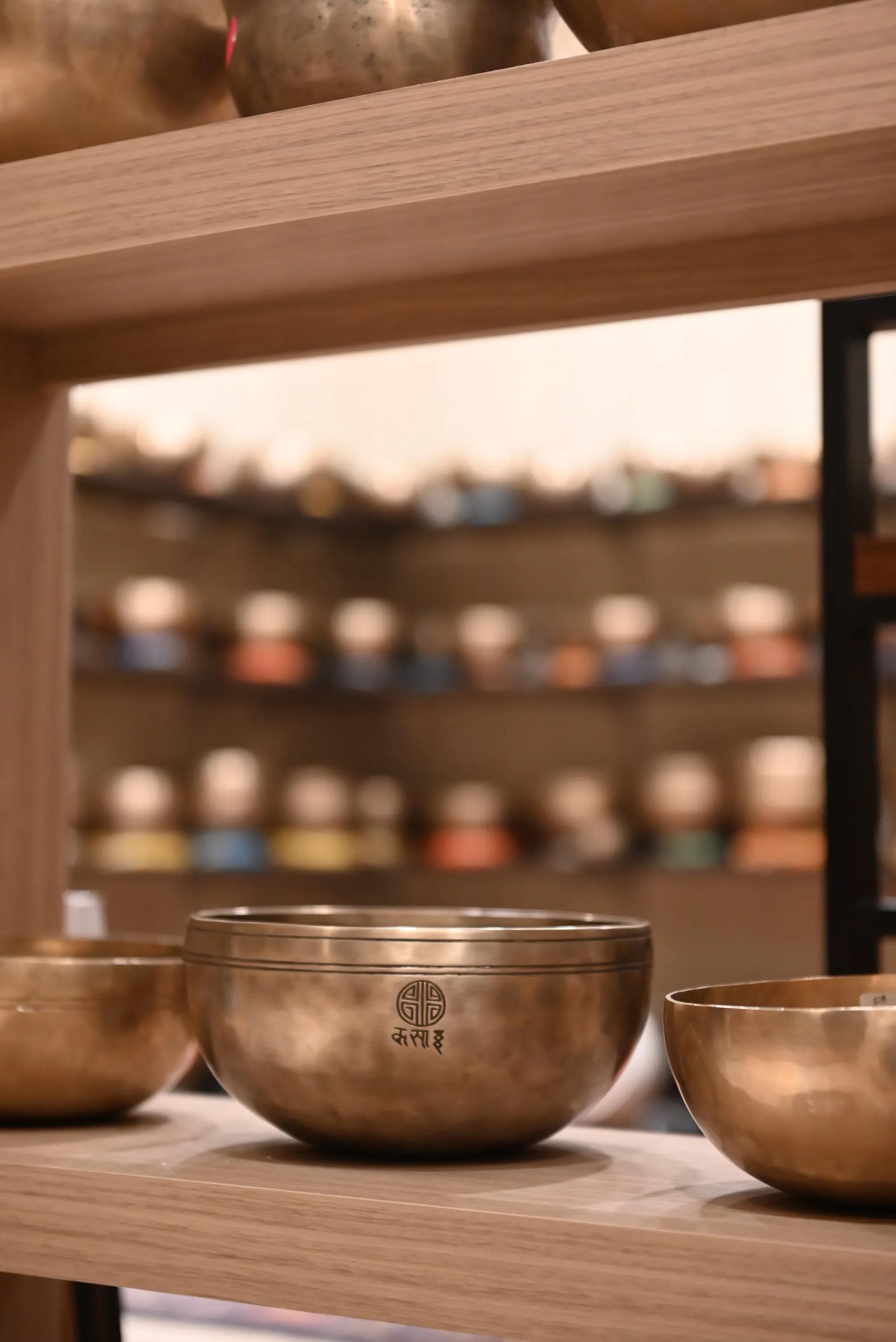 A hand-hammered singing bowl glowing in the last light of a dusk sky over the sea